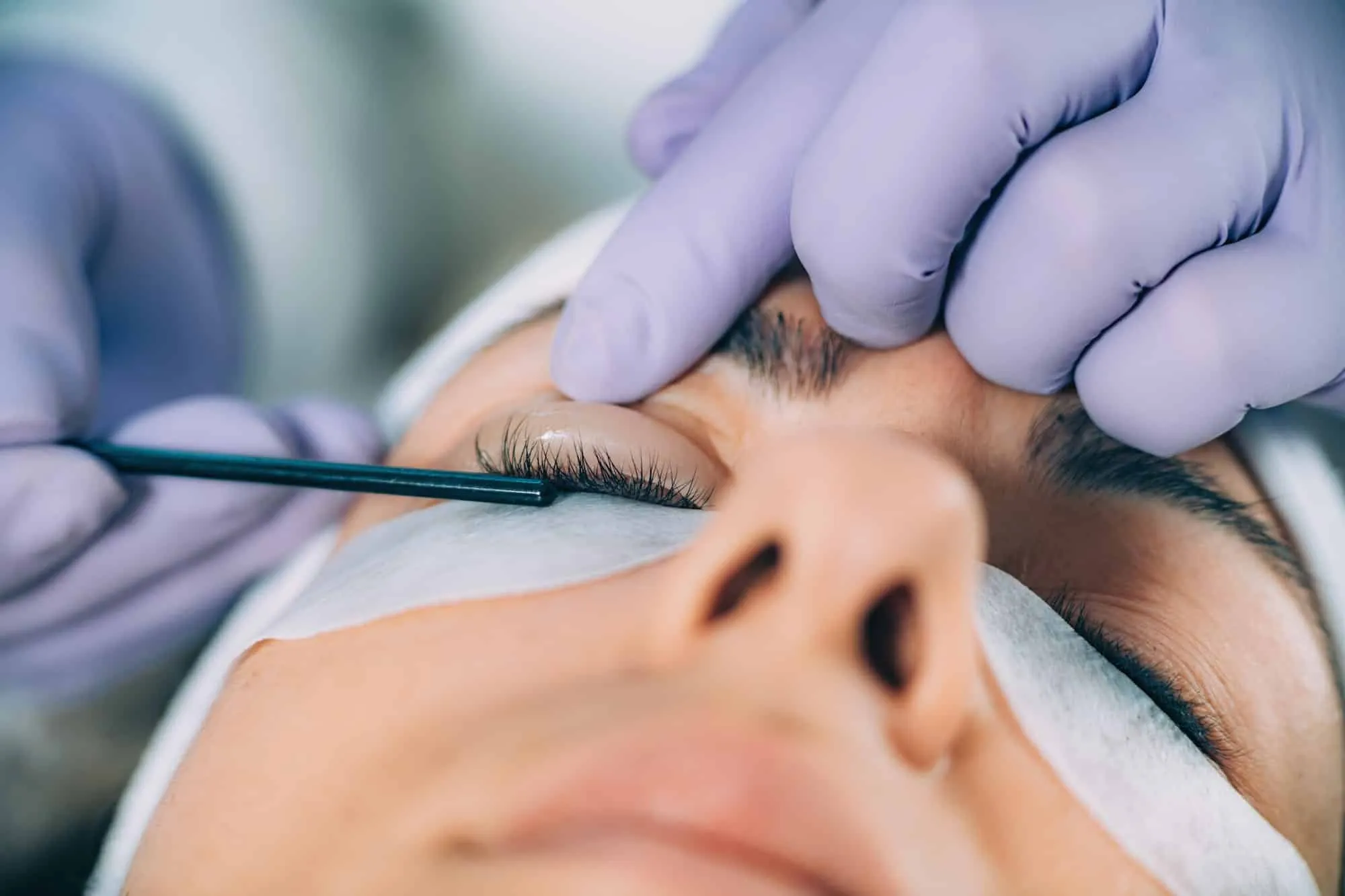 Wimpern werden beim Lashlifting mit einem Stäbchen nach oben gelegt