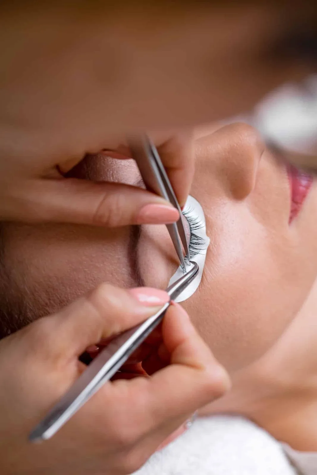 Wimpernverlängerung: Wimpern werden mit zwei Pinzetten gesetzt